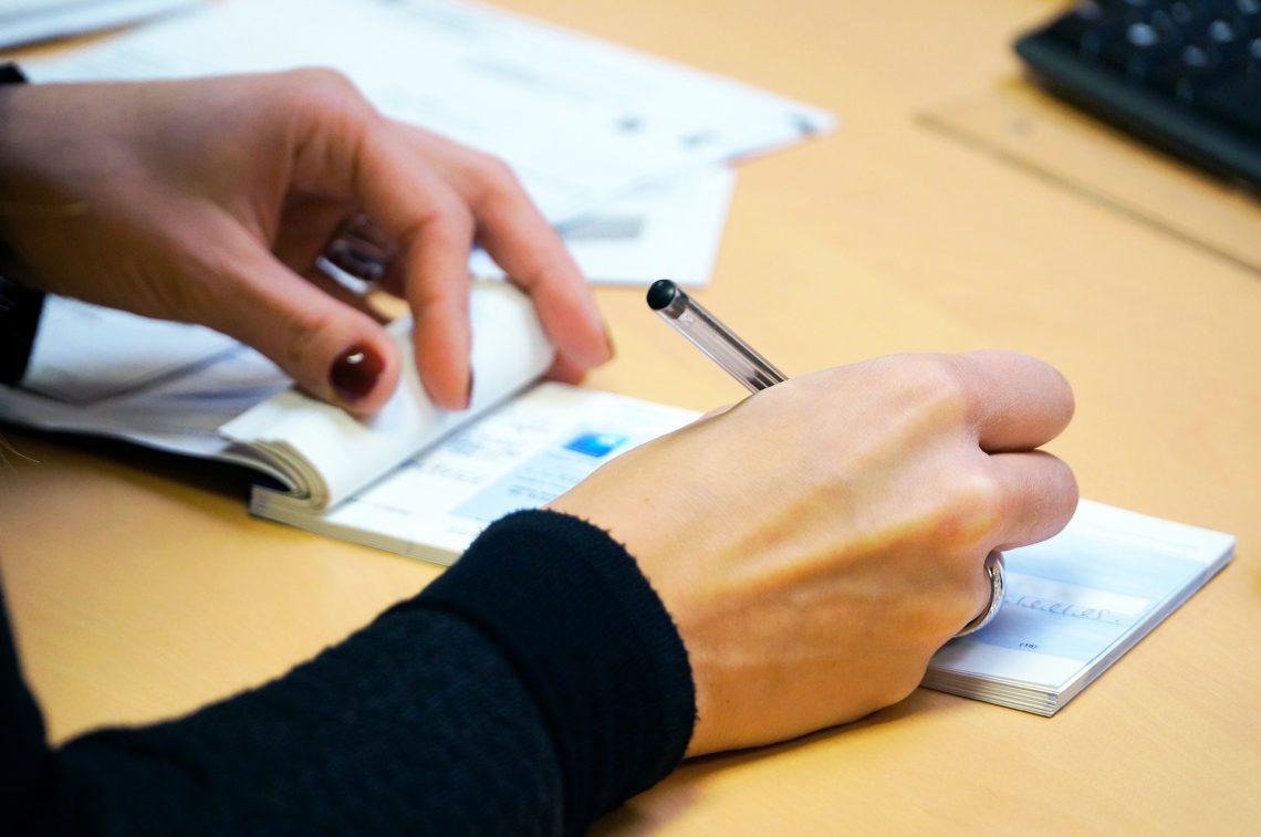 Jeune femme qui remplit un chèque pour payer son loyer