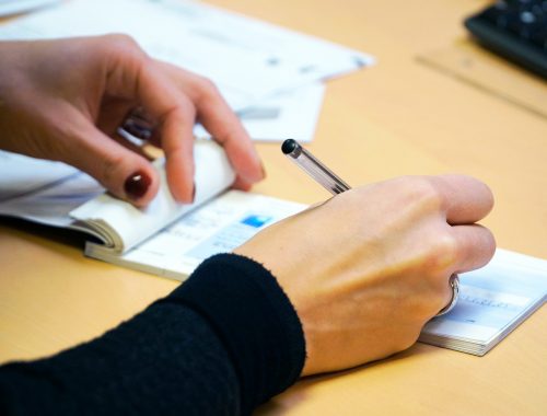 Jeune femme qui remplit un chèque pour payer son loyer