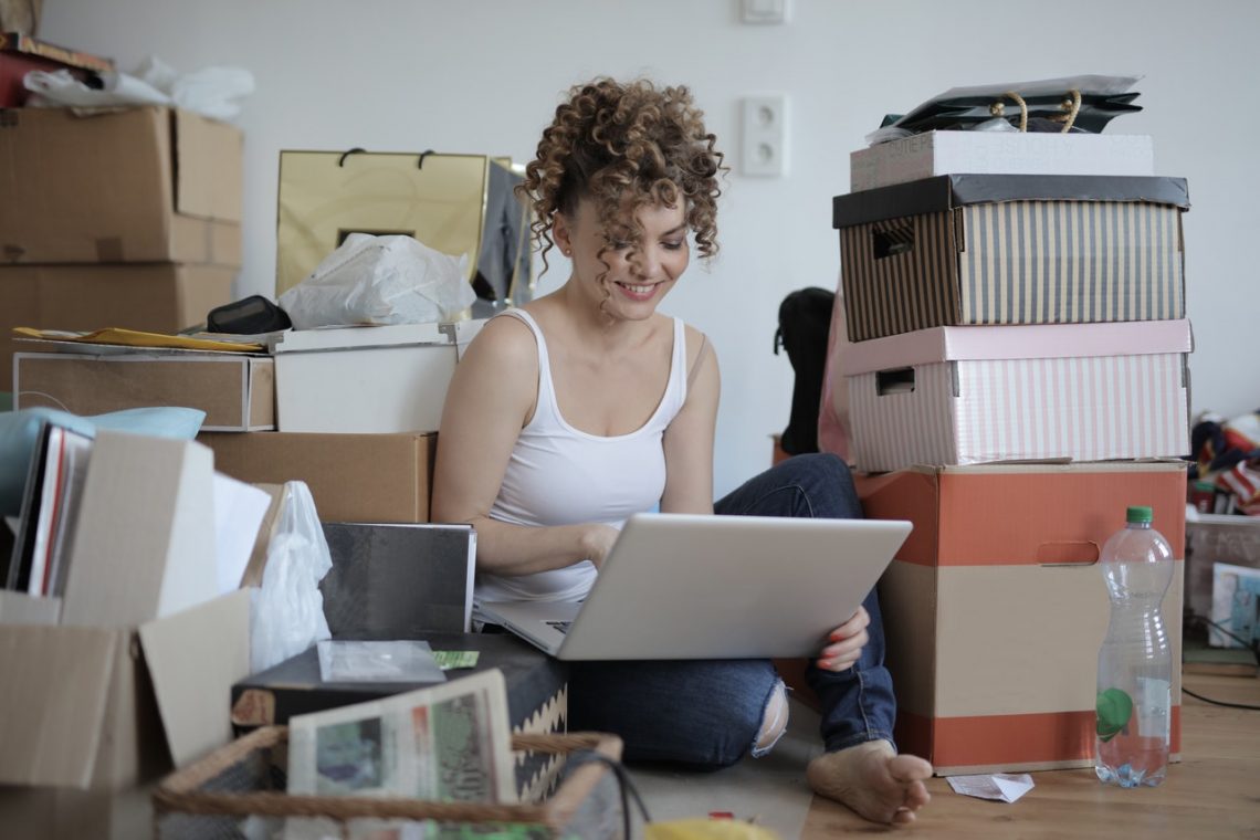 jeune femme assise au milieu de cartons de déménagement