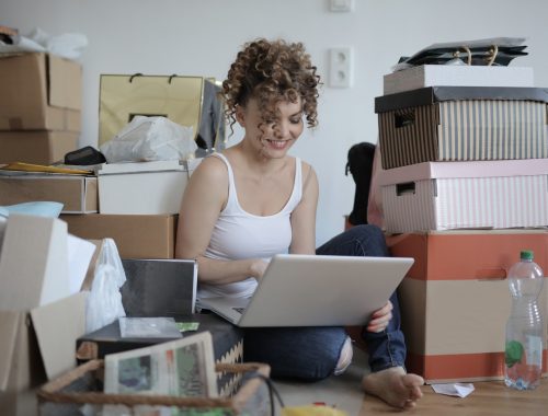 jeune femme assise au milieu de cartons de déménagement